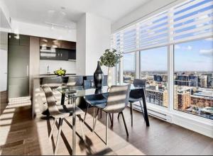 a kitchen with a table and chairs and a large window at Amazing city view - Penthouse - Pool & Spa - Downtown Montreal in Montreal