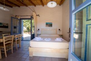 1 dormitorio con 1 cama, mesa y sillas en Residence Isola dei Mori en SantʼAntìoco