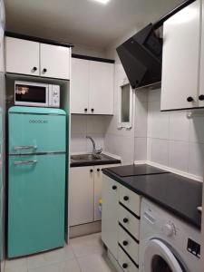 een keuken met een groene koelkast en een magnetron bij REX CUATRO in Benidorm