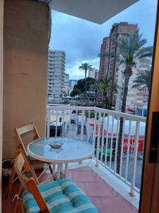 een balkon met een tafel en uitzicht op de stad bij REX CUATRO in Benidorm