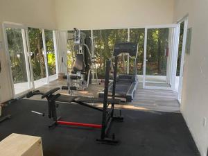 a room with a gym with a treadmill and a simulator at Casa Kukulkan 1 in Puerto Morelos