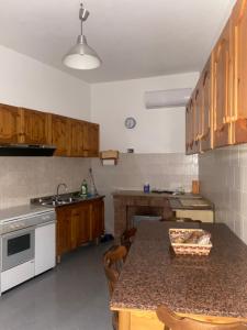 a kitchen with wooden cabinets and a table with a counter top at Affittacamere U’FURNILLO in Cautano