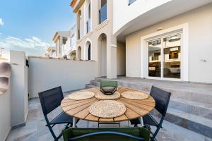 a patio with a wooden table and chairs at Casa Río Júcar Sunrise in San Pedro del Pinatar