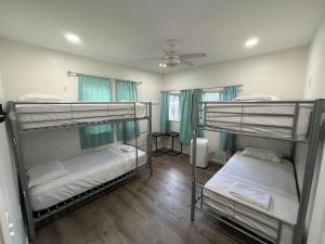 two bunk beds in a room with a ceiling fan at Howzit Hostels in Wailuku