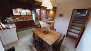 cocina y comedor con mesa de madera en La casita de Maichu en San Martín de los Andes