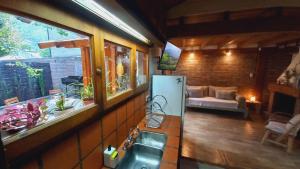 een keuken met een wastafel en een woonkamer met een bank bij La casita de Maichu in San Martín de los Andes