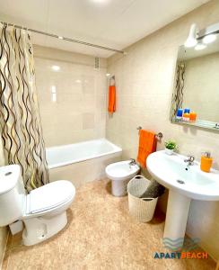 ein Badezimmer mit einem WC, einem Waschbecken und einer Badewanne in der Unterkunft APARTBEACH LOS JUNCOS 2 RESIDENCIAL y JUNTO PLAYA in La Pineda
