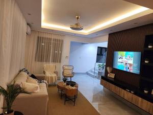 een woonkamer met een bank en een flatscreen-tv bij Luxury Villa in Punta Cana in Punta Cana
