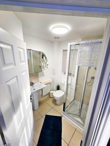 uma casa de banho com um chuveiro, um WC e um lavatório. em Spacious Modern 4BD House em Hull