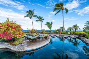 a pool at the resort with palm trees at Halii Kai 11D in Waikoloa