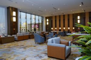 Best Western Plus Danat Almansak Hotel في أبها: لوبي فندق فيه طاولات وكراسي