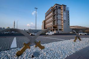 un gruppo di croci su una strada con un edificio di Best Western Plus Danat Almansak Hotel a Abha