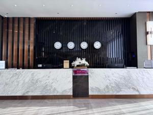 a lobby with a counter with clocks on the wall at Best Western Plus Danat Almansak Hotel in Abha