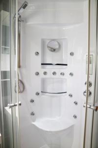 a white bathroom with a shower and a toilet at Duddingston Guest House in Edinburgh