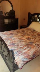 a bedroom with a bed with a comforter on it at Appartement a loué fes in Fès