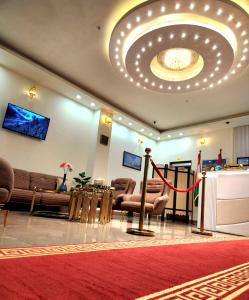 a lobby with a waiting room with a red carpet at Vote Hotel in Erbil