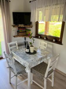 a dining room table with chairs and a table with wine glasses at Przytulny Domek z Banią in Brzozowa