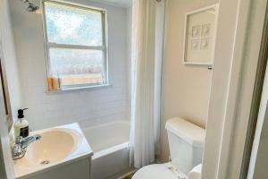 un bagno con lavandino, water e finestra di Cozy Cottage only 4 Blocks from the Ocean a Jacksonville Beach