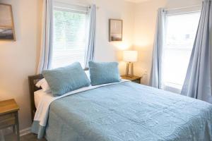 1 dormitorio con 1 cama azul y 2 almohadas en Cozy Cottage only 4 Blocks from the Ocean en Jacksonville Beach