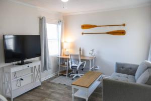 un soggiorno con una TV, un divano e un tavolo di Cozy Cottage only 4 Blocks from the Ocean a Jacksonville Beach