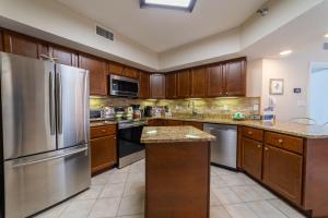 a large kitchen with wooden cabinets and stainless steel appliances at Pelican Pointe 504 in Orange Beach