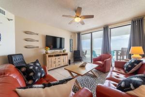 a living room with a couch and chairs and a tv at Pelican Pointe 504 in Orange Beach