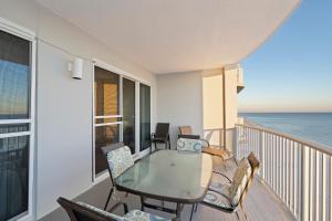 balcón con mesa, sillas y vistas al océano en Island Royale 902 Gulf Front Condo, en Gulf Shores