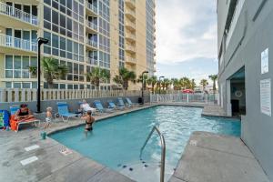 una familia jugando en una piscina en un hotel en Island Royale 902 Gulf Front Condo, en Gulf Shores