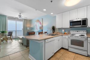 a kitchen with white cabinets and a counter top at Lighthouse By Liquid Life in Gulf Shores