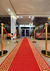 a red carpet in a hotel lobby with a red ribbon at Vote Hotel in Erbil