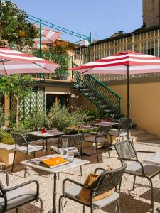 an outdoor patio with tables and chairs and umbrellas at The Sonetto powered by Sonder in Florence