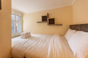 um quarto com uma cama com toalhas em Westminster Charm with Roof Terrace em Londres