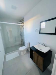 a bathroom with a toilet and a sink and a mirror at FlyNow Studios - Aeroporto Sp Expo Metrô in São Paulo