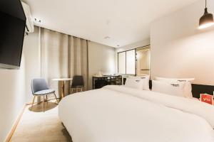 sypialnia z dużym białym łóżkiem i biurkiem w obiekcie 2 Heaven Hotel Songdo w Pusanie