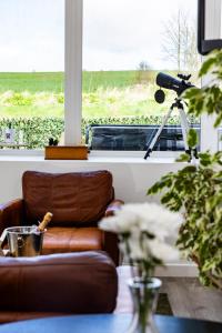 a room with a couch and a camera in a window at Ladyston Barn in Muthill