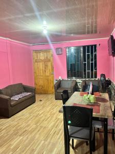 sala de estar con paredes rosas, mesa y sofá en Apartamento caribe sur en Puerto Limón