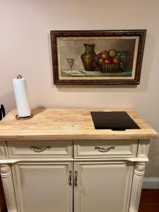 a wooden counter with a bowl of apples and a painting at Charming 1-bedroom Basement Close to DC Pets Allowed in Arlington