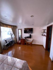 uma sala de estar com piso de madeira e uma televisão em Hermosa casa con gran ubicación em Bogotá