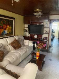 a living room with a white couch and a television at Hermosa casa con gran ubicación in Bogotá