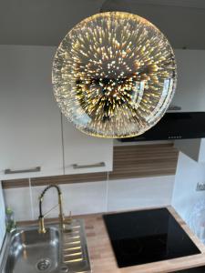 a kitchen with a sink and a chandelier at Appartement de charme avec balcon au pied des commerces in Béziers +28 photos