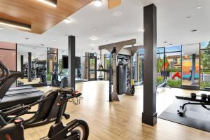 um ginásio com passadeiras e máquinas elípticas em Irvine Luxury & Modern Home em Santa Ana