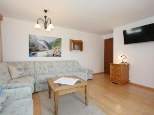 uma sala de estar com um sofá e uma mesa em Schleicherhof IV em Strass im Zillertal