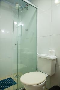 a bathroom with a toilet and a glass shower at Pousada Locomotiva 206 in Conservatória