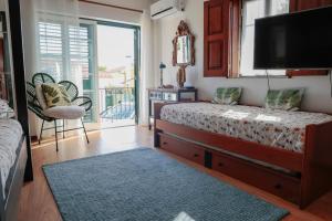 Schlafzimmer mit einem Bett, einem TV und einem Balkon in der Unterkunft Casa do Vale - Moradia-Rio Minho-Seixas-Caminha - Casa de férias completa com piscina in Caminha