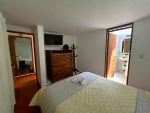 Schlafzimmer mit einem Bett, einer Kommode und einem Spiegel in der Unterkunft Anhyali Hospedaje in Villa de Leyva