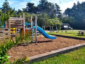 a playground with a slide in a park at South Brighton Holiday Park in Christchurch