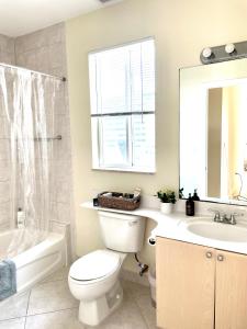 ein Badezimmer mit einem WC, einem Waschbecken und einem Spiegel in der Unterkunft Private bedroom in Miami Coral Gables in Miami