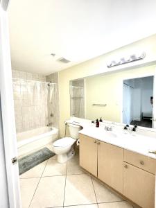 a bathroom with a toilet and a tub and a sink at Private bedroom in Miami Coral Gables in Miami