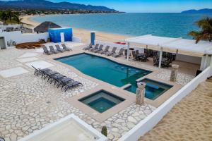 una piscina en la playa junto al océano en Palacio Blanco Luxury Villa 1 en La Ventana
