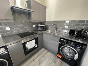 uma cozinha com uma máquina de lavar roupa e um lavatório em RYAN I AIR I BNB - 458 Mill Street - Free Parking em Liverpool